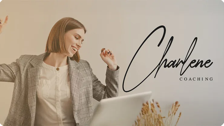 A woman laughing at her laptop beside the Charlene Coaching wordmark